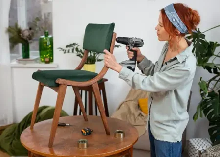 Mulher montando cadeira com uma parafusadeira