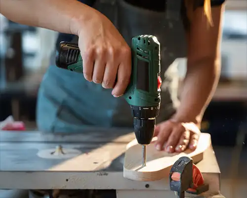 Homem montando um móvel com uma parafusadeira