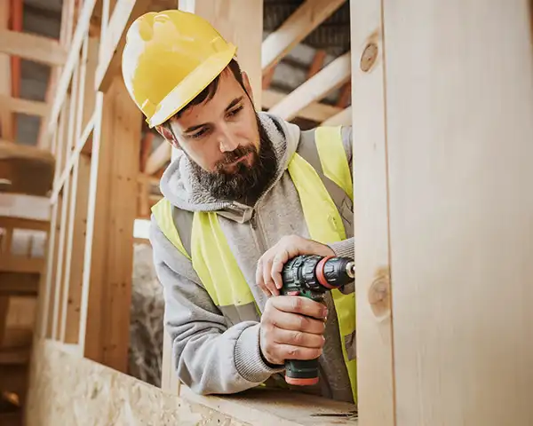Homem montando um móvel com uma parafusadeira