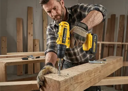 Homem montando um móvel com uma parafusadeira