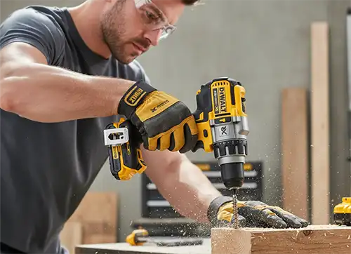 Homem montando um móvel com uma parafusadeira