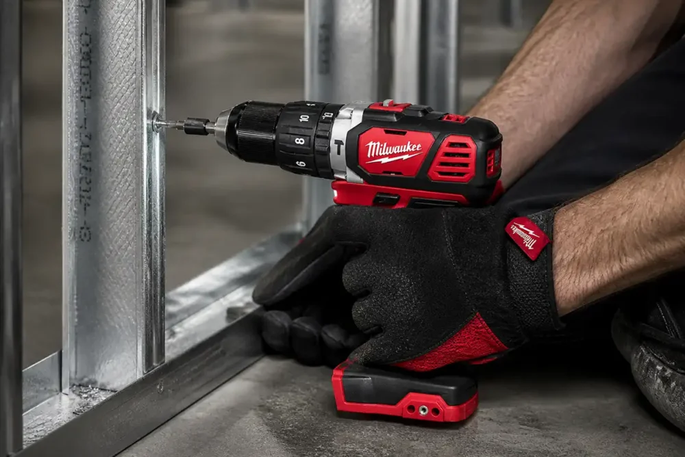 Parafusadeira Milwaukee 2606 M18 fixando perfil metálico de drywall com luva de proteção