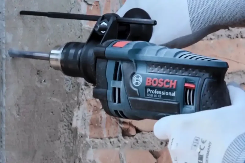 Furadeira para concreto Bosch GSB 16 RE perfurando parede de alvenaria com broca de vídea.