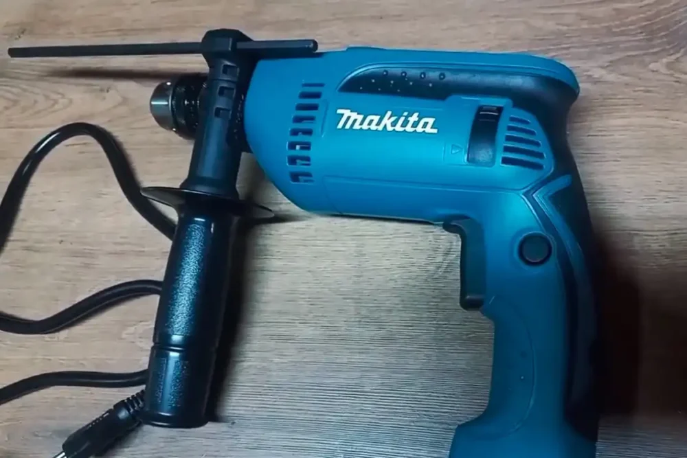 Furadeira para concreto Makita HP1640 com punho lateral e limitador de profundidade, vista lateral.