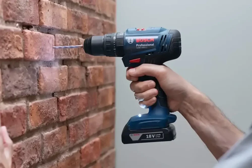 Parafusadeira Bosch GSB 183-LI Professional furando parede de tijolo, com bateria 18V 2,0 Ah acoplada